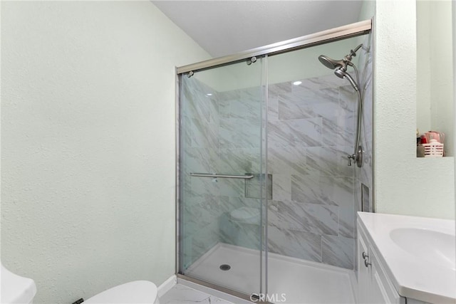 bathroom featuring vanity, toilet, and a shower with shower door