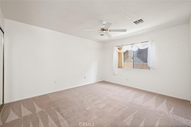 empty room with ceiling fan and light colored carpet