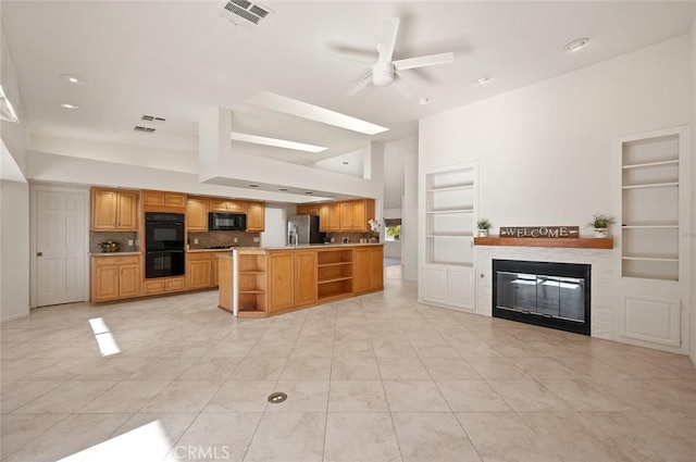 kitchen with built in features, ceiling fan, backsplash, black appliances, and kitchen peninsula