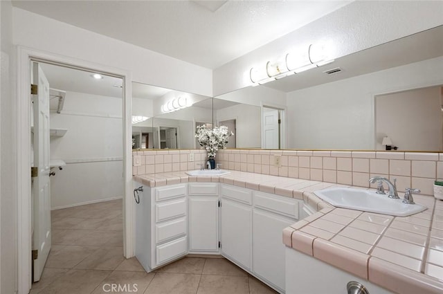 bathroom with vanity, tile patterned flooring, and decorative backsplash