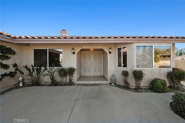 view of exterior entry featuring a patio