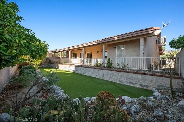 rear view of house featuring a yard