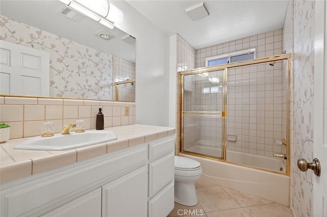 full bathroom featuring vanity, tile patterned floors, shower / bath combination with glass door, and toilet