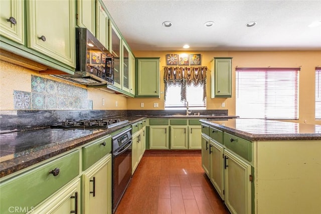 kitchen featuring dark hardwood / wood-style floors, black appliances, dark stone counters, and green cabinetry