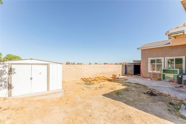 view of yard featuring central AC and a shed