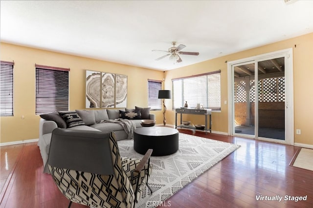 living room with ceiling fan and dark wood-type flooring