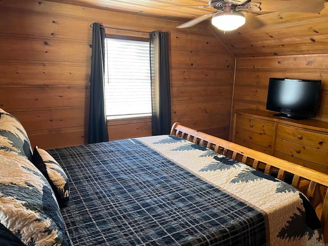 bedroom with ceiling fan, wood walls, and wooden ceiling