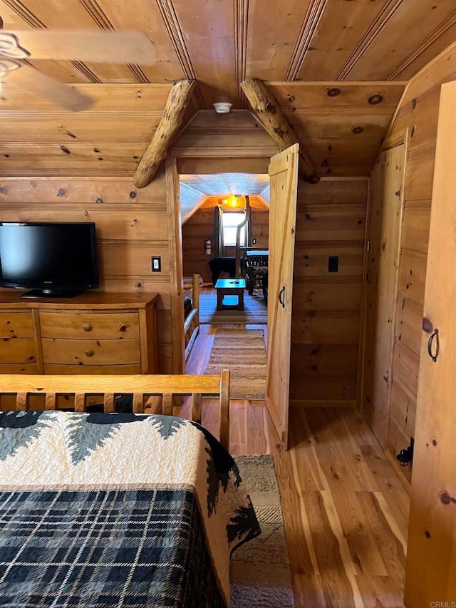 bedroom featuring lofted ceiling, wood walls, hardwood / wood-style flooring, and wooden ceiling