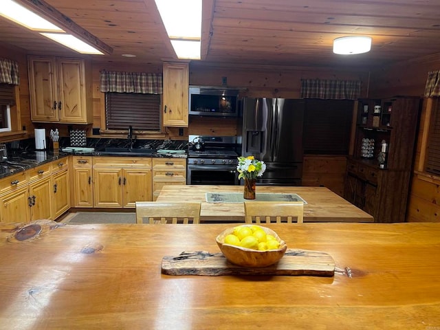 kitchen with appliances with stainless steel finishes, wood ceiling, and sink