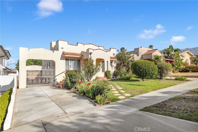 mediterranean / spanish house featuring a front lawn