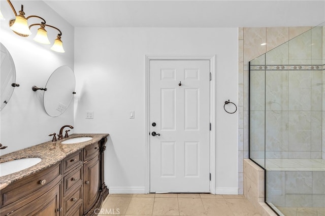 bathroom with vanity, tile patterned flooring, and tiled shower