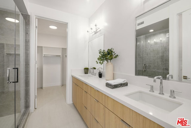 bathroom featuring vanity and a shower with door