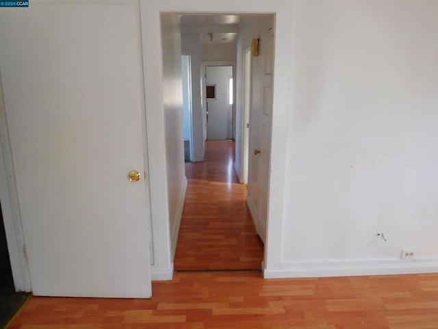 corridor with light hardwood / wood-style floors