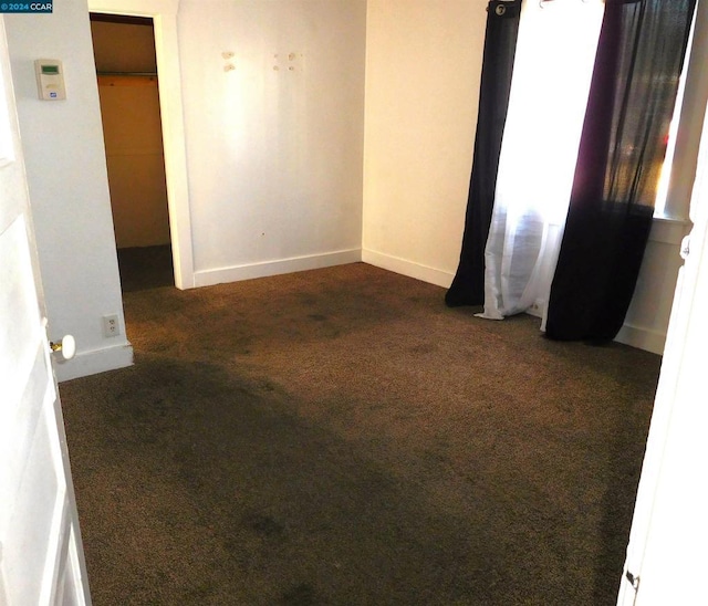 empty room with dark colored carpet