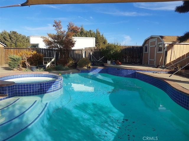 view of swimming pool featuring a storage shed and an in ground hot tub