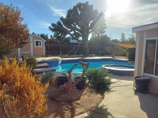 view of swimming pool with an in ground hot tub and a storage shed