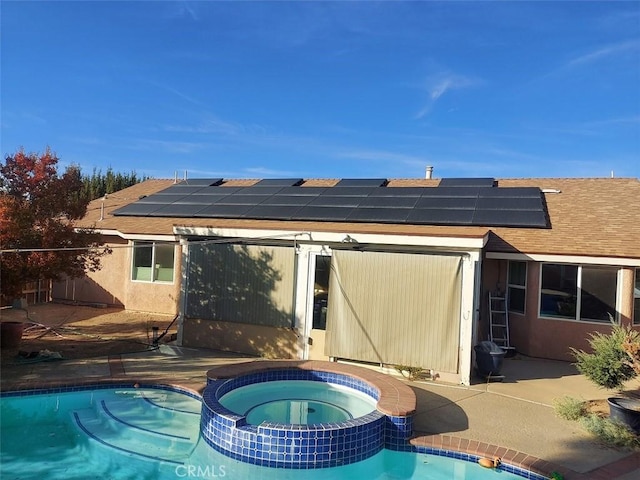 rear view of property featuring a patio area and a pool with hot tub