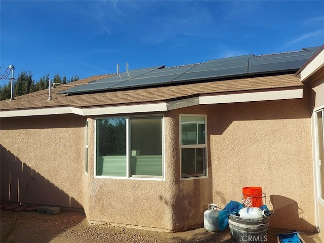 view of side of property featuring solar panels