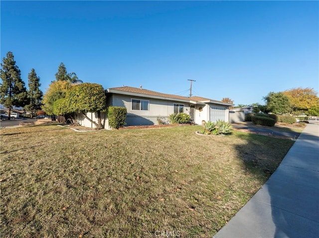 ranch-style house featuring a garage and a front lawn