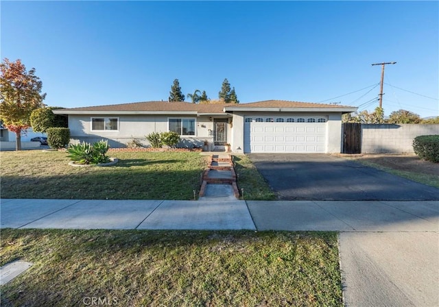 ranch-style house featuring a garage and a front lawn