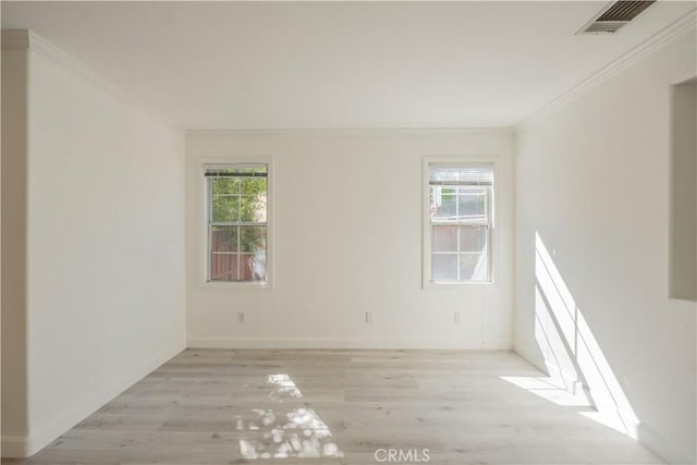 unfurnished room featuring plenty of natural light, light hardwood / wood-style floors, and crown molding