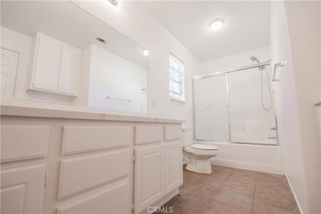 full bathroom with tile patterned flooring, vanity, toilet, and bath / shower combo with glass door