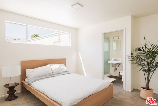 bedroom with connected bathroom and carpet floors