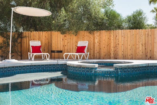 view of swimming pool featuring an in ground hot tub