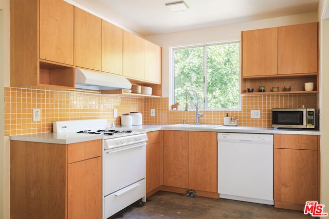 kitchen with decorative backsplash, white appliances, and sink