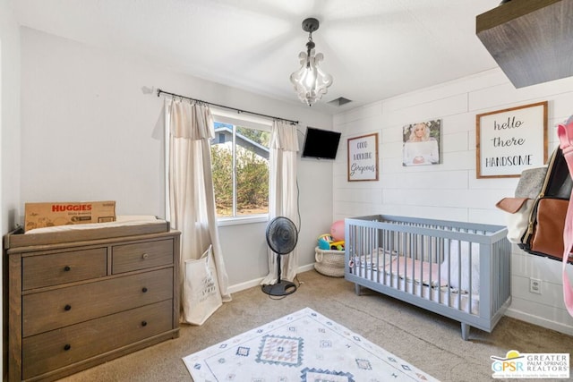 bedroom with light colored carpet and a nursery area