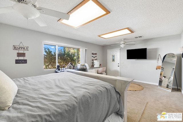 bedroom featuring ceiling fan, a textured ceiling, and light colored carpet