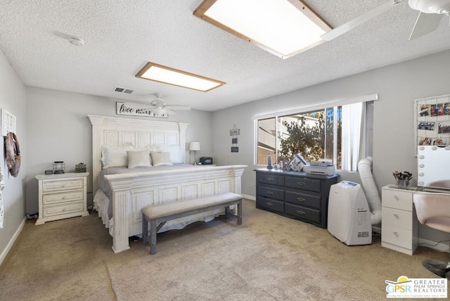 bedroom with ceiling fan, a textured ceiling, and light colored carpet