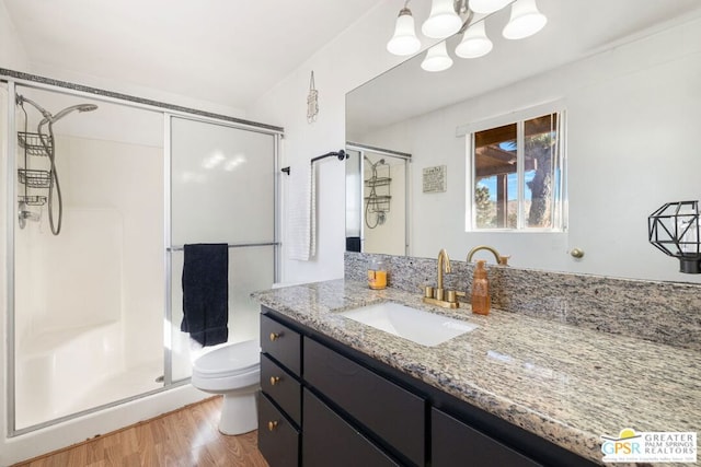 bathroom with vanity, toilet, hardwood / wood-style flooring, and walk in shower