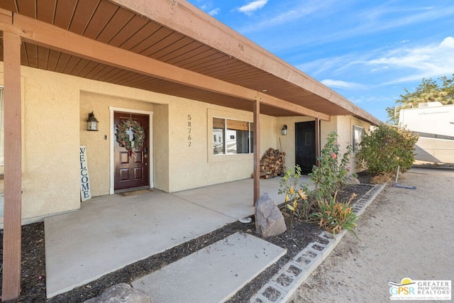 view of exterior entry featuring a patio area