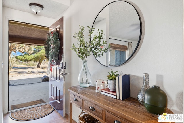 foyer featuring wood-type flooring and a textured ceiling