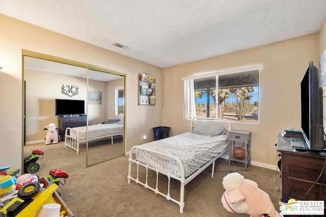 bedroom with a closet, a textured ceiling, and carpet flooring