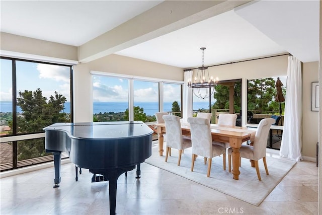 dining space with a water view, a wealth of natural light, and a notable chandelier