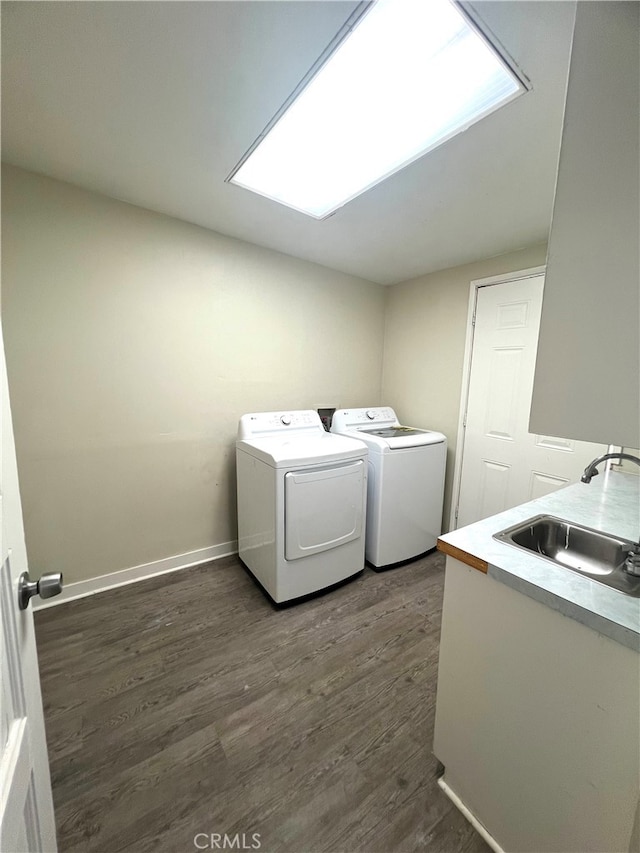 laundry room featuring sink, washing machine and clothes dryer, and dark hardwood / wood-style floors