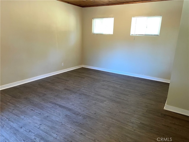 spare room featuring dark wood-type flooring and wooden ceiling