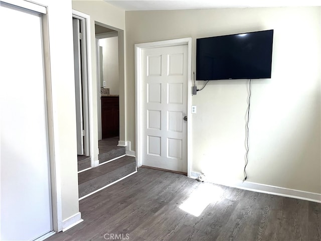 unfurnished bedroom with dark wood-type flooring and vaulted ceiling