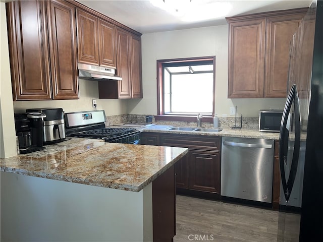 kitchen featuring sink, dishwasher, fridge, dark wood-type flooring, and range with gas stovetop