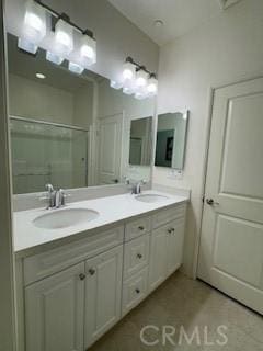 bathroom featuring vanity and a shower with door