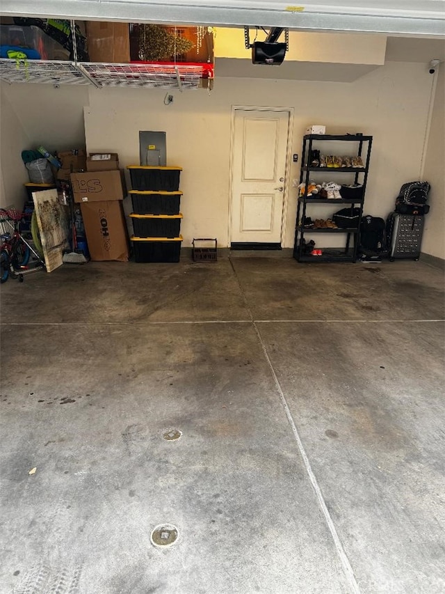 garage featuring electric panel and a garage door opener