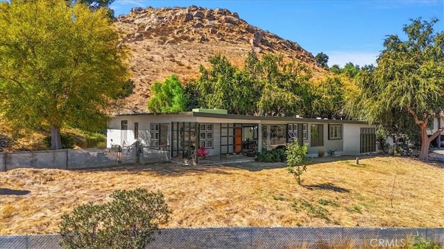 view of front facade featuring a mountain view and a front lawn