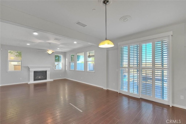 unfurnished living room featuring ceiling fan and dark hardwood / wood-style flooring