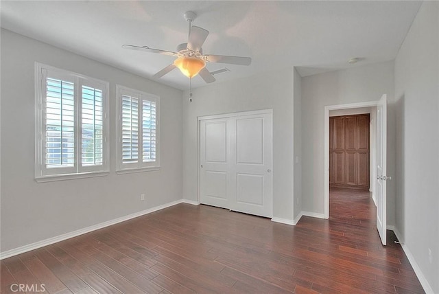 unfurnished bedroom featuring ceiling fan, dark wood-type flooring, and a closet