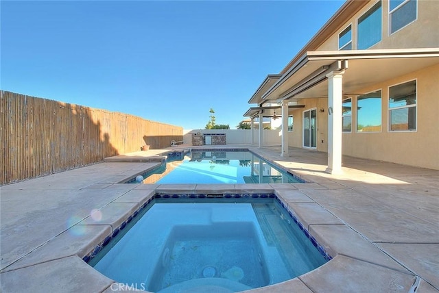 view of pool with a patio area and an in ground hot tub