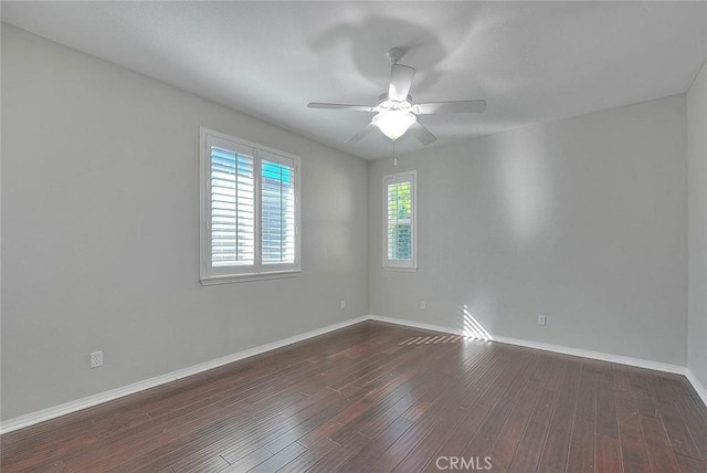 empty room featuring dark hardwood / wood-style flooring and ceiling fan