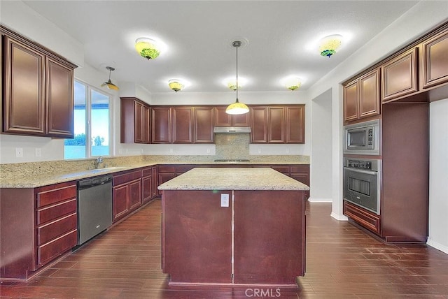 kitchen featuring decorative light fixtures, a center island, dark hardwood / wood-style floors, and appliances with stainless steel finishes