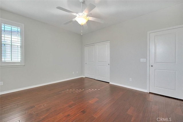 empty room with dark hardwood / wood-style floors and ceiling fan